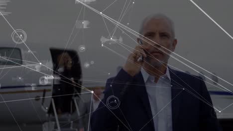 animación del procesamiento de datos sobre un hombre de negocios caucásico hablando por teléfono inteligente