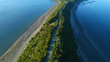 Narrow-channel-on-lemuy-island,-chile,-with-lush-greenery-and-serene-waters,-aerial-view