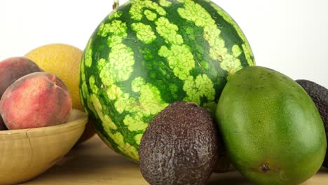 Slider-shot-of-a-mixture-of-fresh-fruit-on-a-chopping-board-against-a-white-backdrop