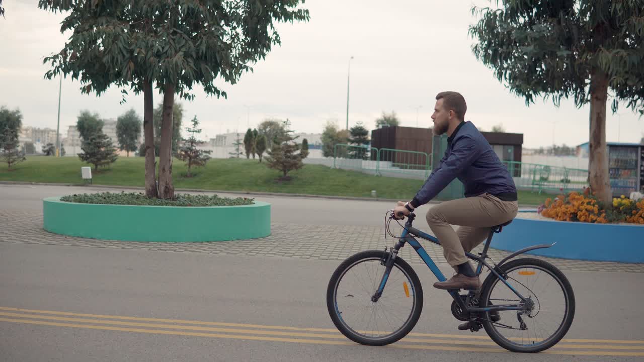 도시 공원을 가로질러 자전거를 타는 남자