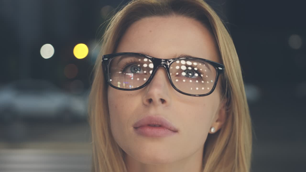 la mujer atractiva con gafas de pie en la calle de la noche. cámara lenta