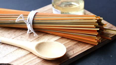 colorful pasta on a wooden cutting board with spoon