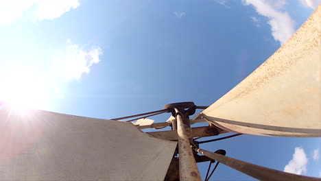 metallic windmill slowly turning by a light wind breeze