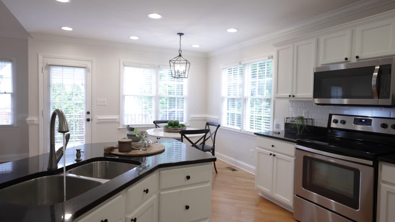 Bright, white kitchen, fully equipped during day time.