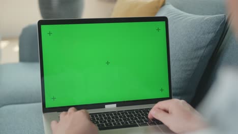 male working on laptop with green screen display, video in 4k