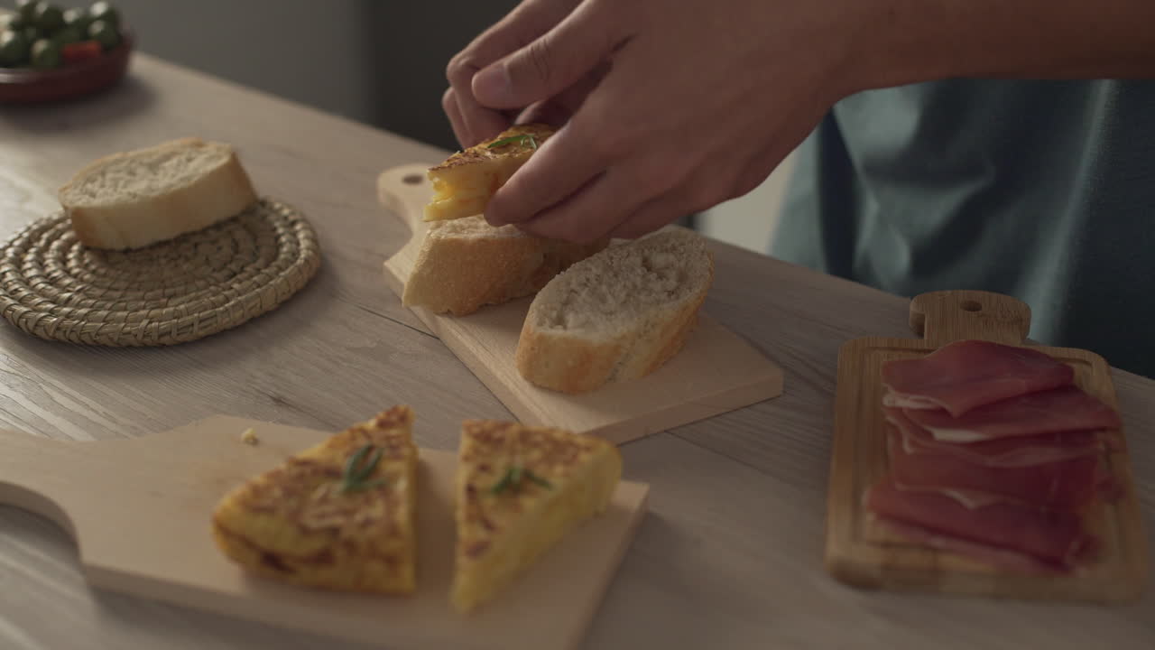 Preparing Spanish omelette pinchos, with bread and serrano ham