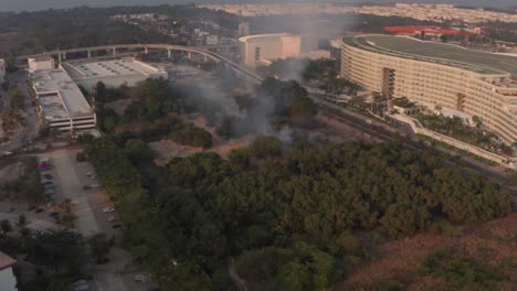 Vista-Aérea-De-Fuego-Y-Humo-En-El-Parque-En-El-Barrio-De-La-Bahía-De-Acapulco,-México