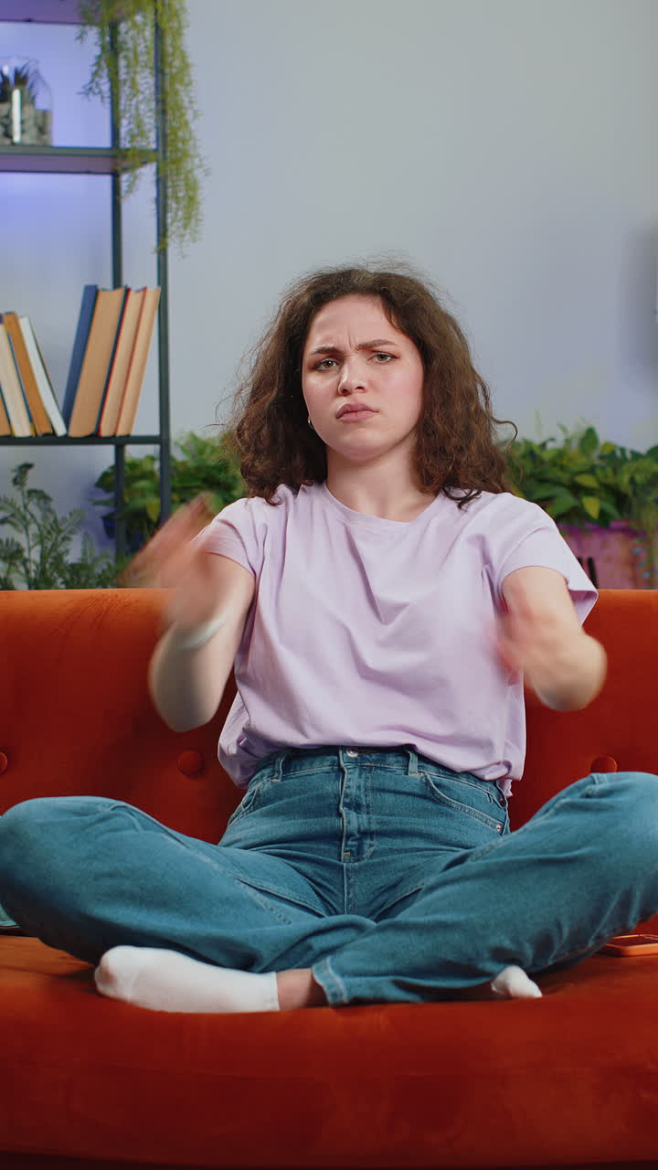 Upset young woman showing thumbs down dislike bad work disapproval dissatisfied feedback at home