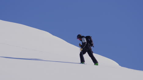 freeride skier skinning up with dents du midi backdrop, then charging steep powder on a bluebird day near champéry and avoriaz.