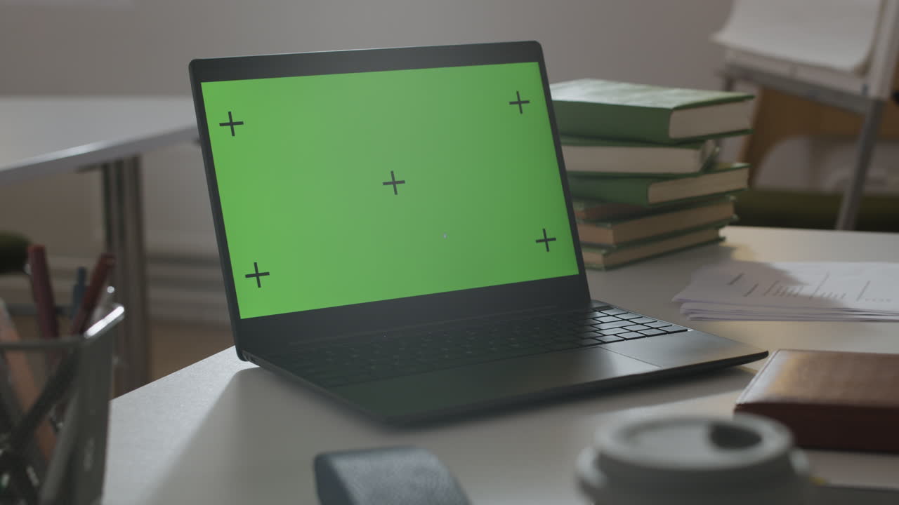 책상 위에 초록색 화면이 있는 노트북
