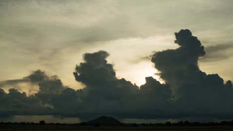 Silhouette-storm-cloud-formation-and-rain-against-the-setting-sun-during-South-East-Asia's-monsoon-season