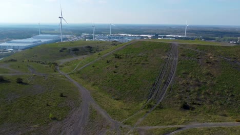 Beautiful-mining-terril-with-wind-turbines-behind,-aerial-drone-view