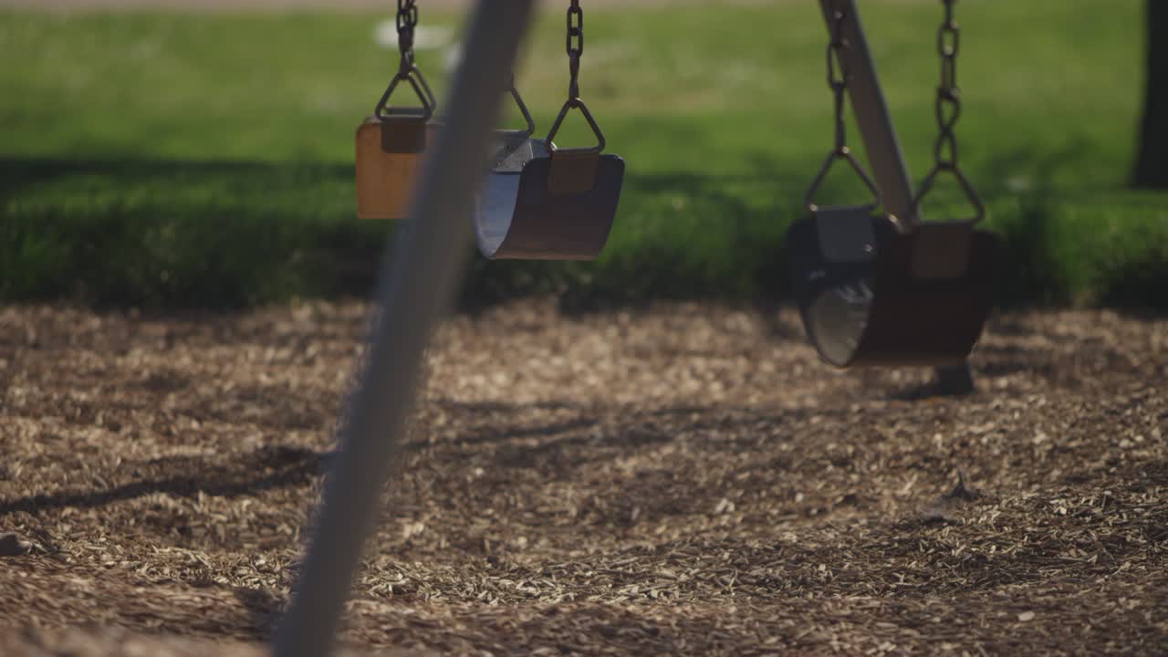rack se centra en los columpios del patio de recreo cubiertos con cinta de advertencia durante una cuarentena