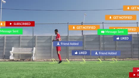 animación de iconos de las redes sociales contra jugadores de fútbol masculinos biraciales entrenando en el campo deportivo