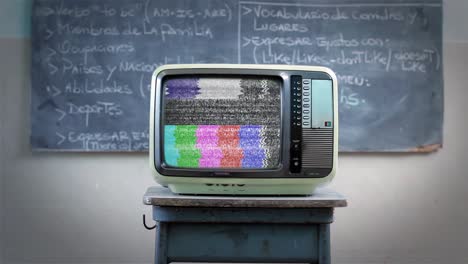 televisión antigua con pantalla azul de tecla de croma contra un tablero en el aula. zoom en. resolución 4k.