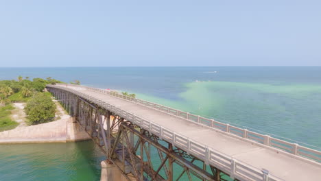 aerial pullback above old concrete bridge and fenced off edge missing connecting section to complete transportation way