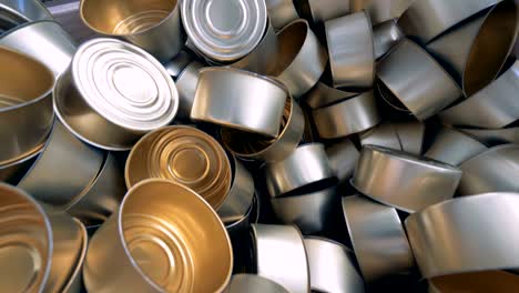 close up of a stack of empty tin cans laying in a wooden box