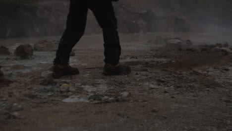 iceland landscape, geothermal hotspring steam smoke, medium closeup of a persons legs walking across the frame