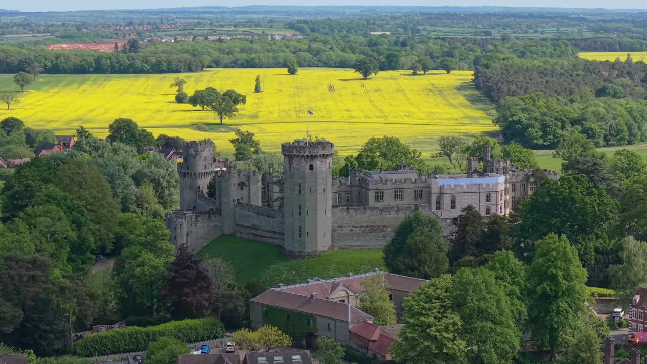 Borgfengselet i Warwick, omgitt av blomstrende vårenger, skaper et fargerikt og naturskjønt landskap som fremhever middelalderarkitektur og et levende bygdelandskap.