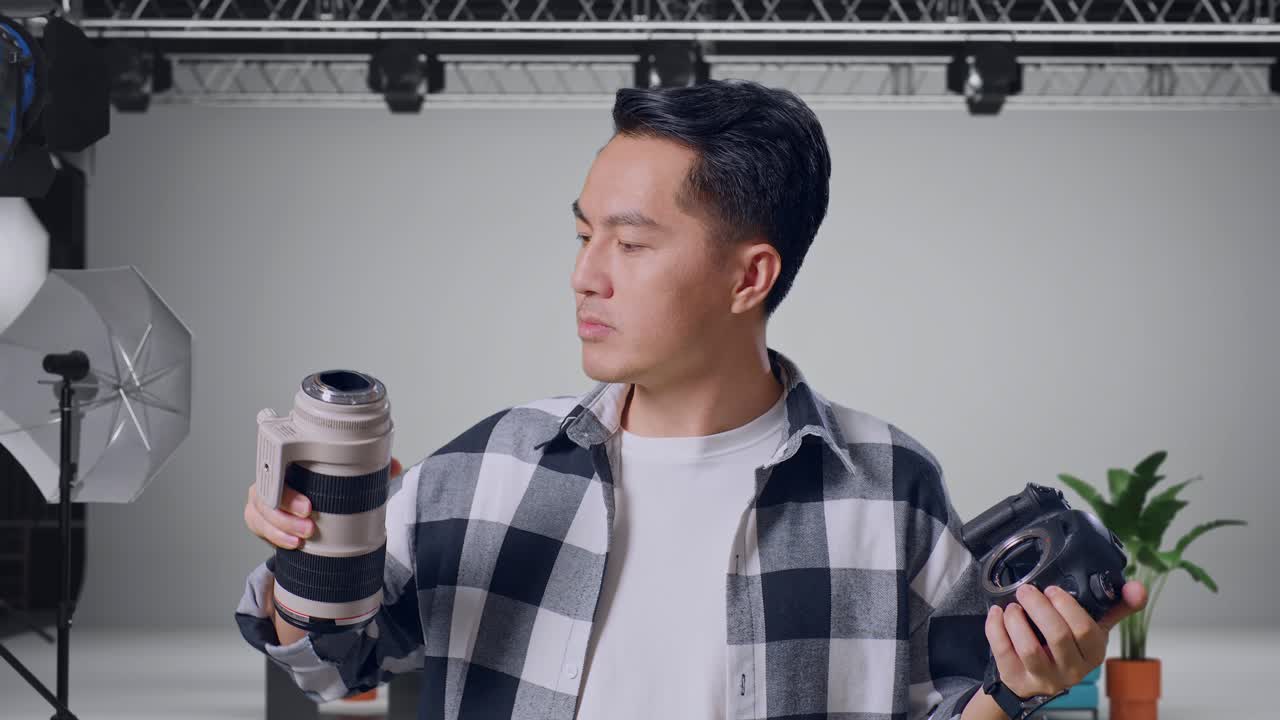 Close Up Of Asian Photographer Changing Lens Of Camera Before Using It Taking Pictures While Standing In The Studio