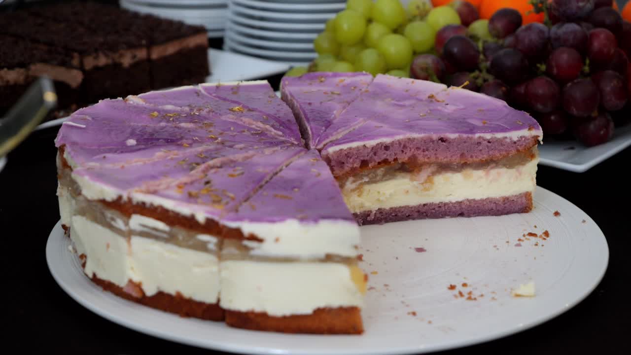 pastel de arándanos, de tres capas, cortado en rebanadas triangulares en una mesa con golosinas