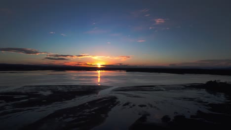 aerial shot of the beautiful sun setting over the ocean with the sun reflecting