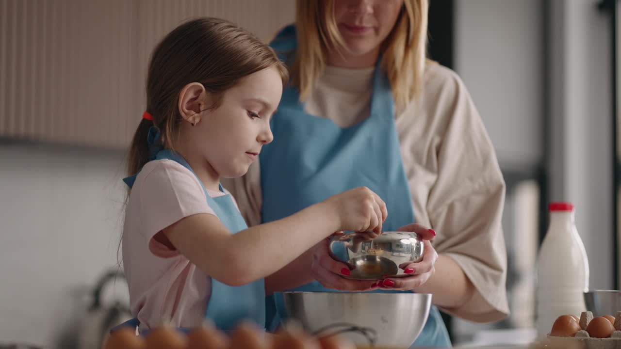 cute and curious little girl is helping to her mother in kitchen pouring sugar in bowl happy childhood