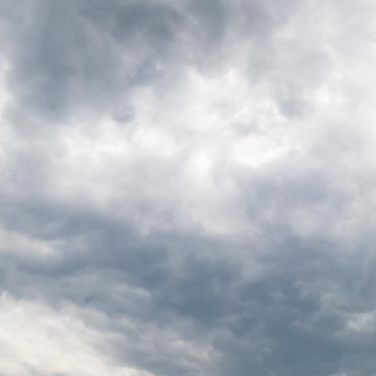 Unpleasant grey cloudscape covered the sky. Dramatic overcast horizon before the rain. Low angle view. Timelapse