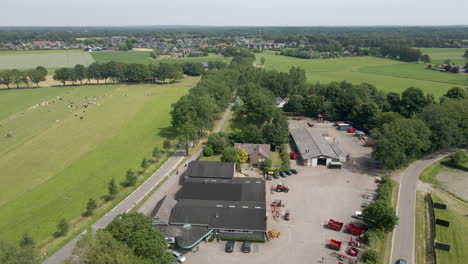 aerial reveal of agricultural company with heavy machinery on lot