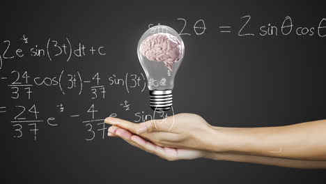 animation of hands holding light bulb with brain over mathematical equations on black background