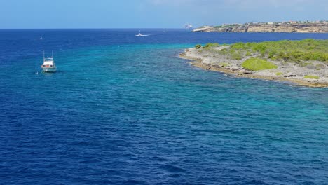 drone orbits around dive boat anchored off shore at scenic caribbean destination snorkel spot