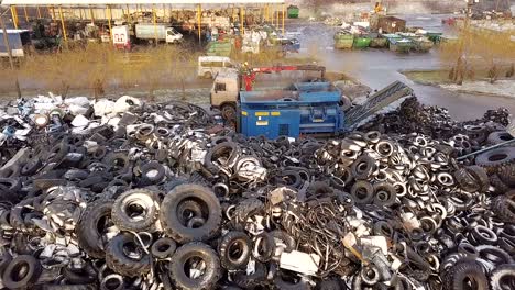 Processing of Wastes. The truck crane loads old tires into the shredder for recycling. Aerial view