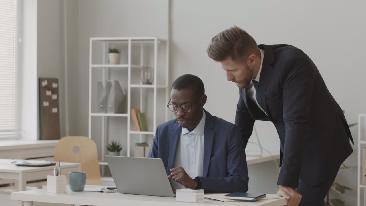 due commercianti diversi in abiti che lavorano insieme in ufficio