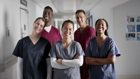 portrait of happy diverse male and female doctors wearing scrubs in hospital, slow motion