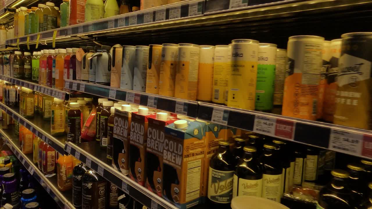 Assortment of Bottled and Canned Beverages on Store Shelves