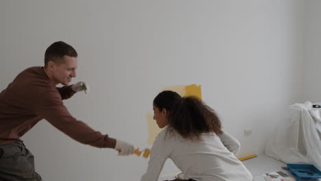 happy couple painting their new home together