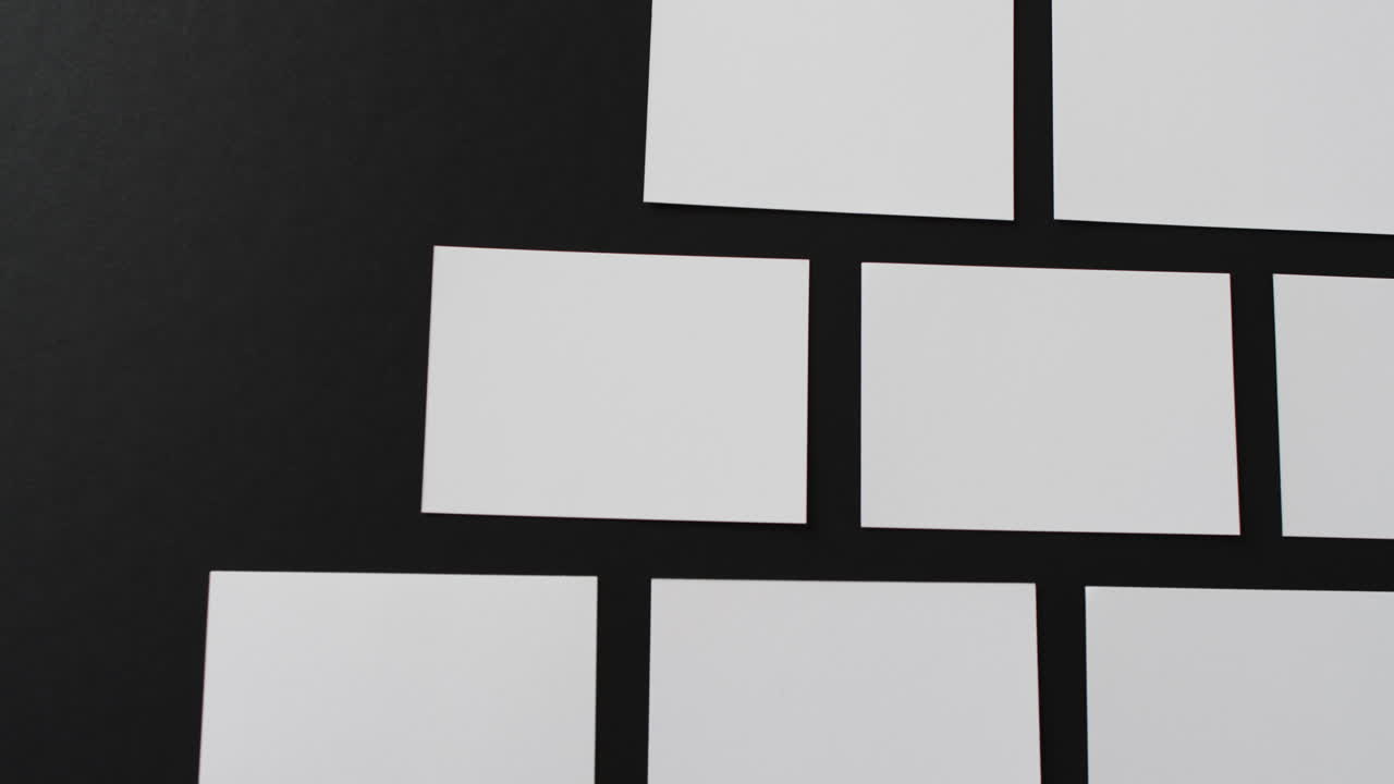 vista aérea de tarjetas de visita blancas dispuestas sobre fondo negro, espacio de copia, cámara lenta