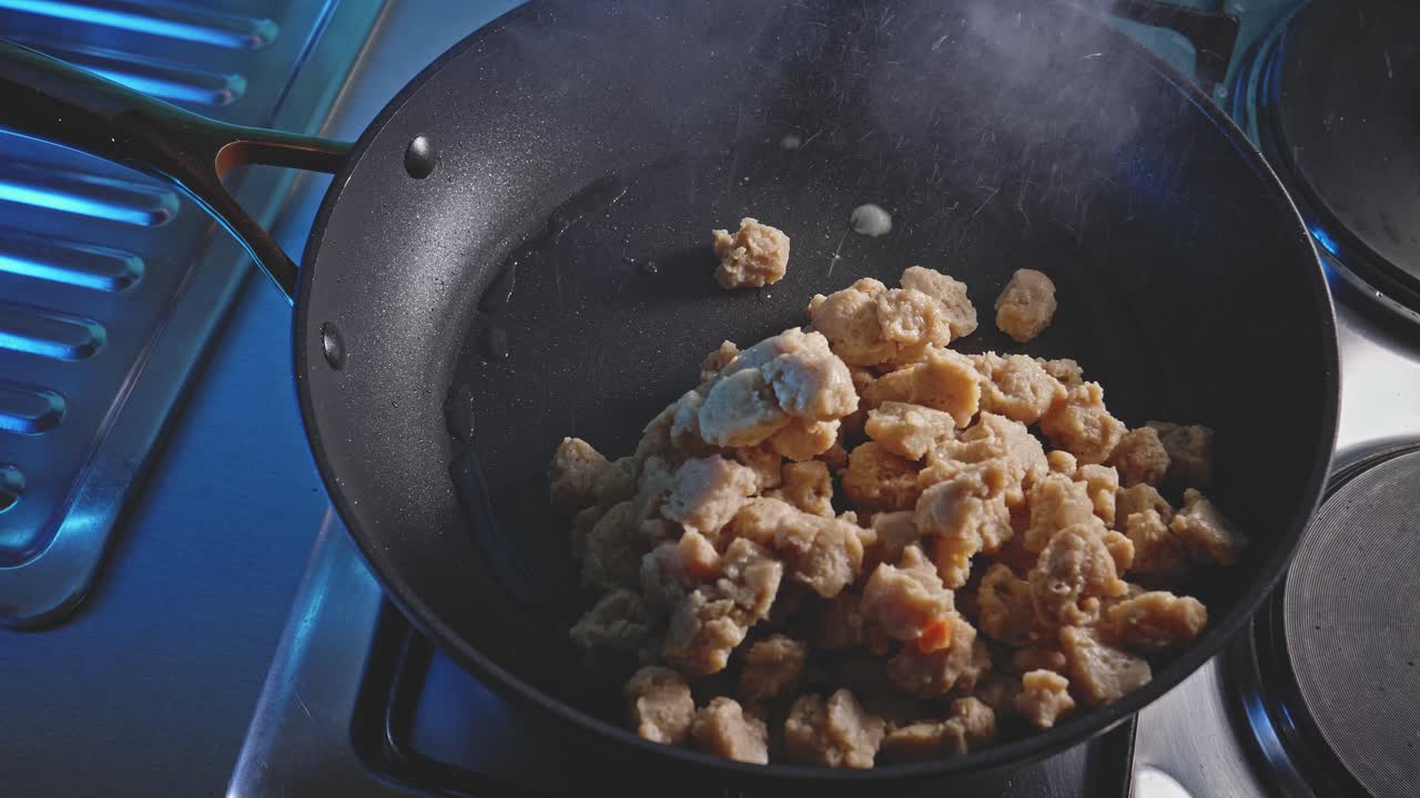 un chef friendo trozos de soja - preparación de soja agridulce con arroz