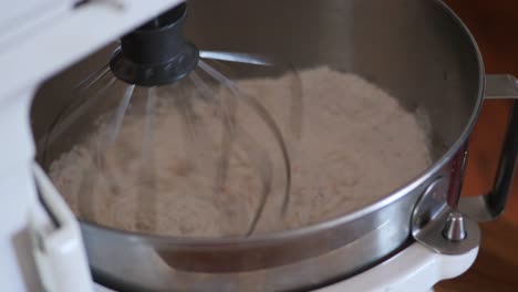 a kitchenaid counter top stand mixer whisking together funfetti birthday cake batter in slow motion