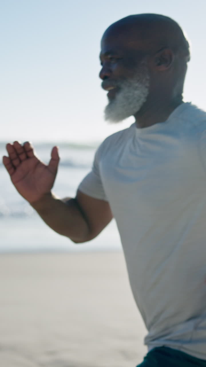 Uomo afroamericano adulto che corre su una spiaggia soleggiata