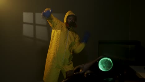 hombre con traje de protección baila en una habitación con niebla