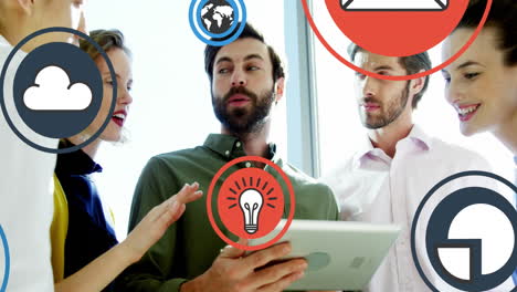 animation of multiple icons over diverse coworkers standing and discussing on digital tablet