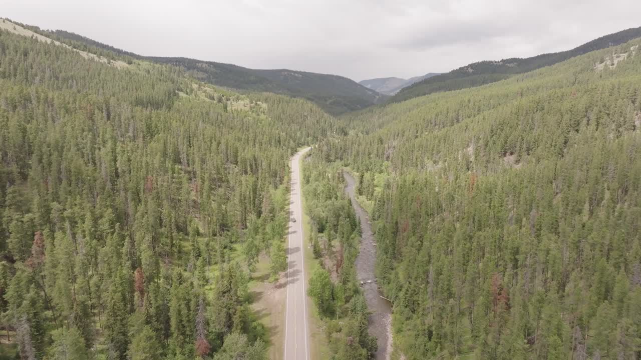 Drone shot of a road cutting through the Canadian mountains