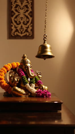 ganesh statue with flowers and bell