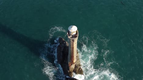 descending to reveal the karori rock lighthouse in the cook strait, new zealand