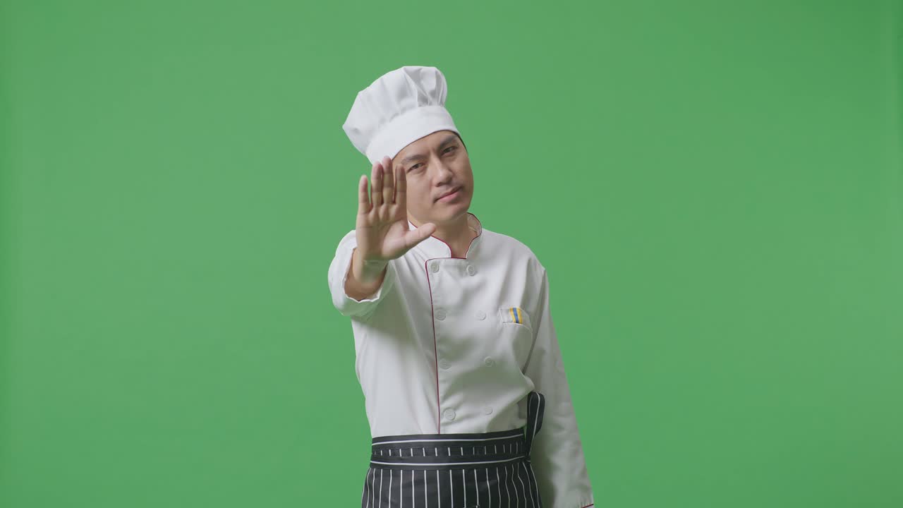Asian Man Chef Looking At Camera And Disapproving With No Hand Sign In The Green Screen Background Studio