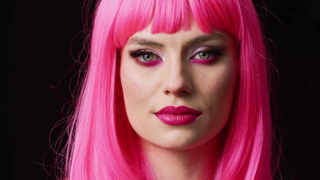Stylish glamour person with pink wig posing in studio