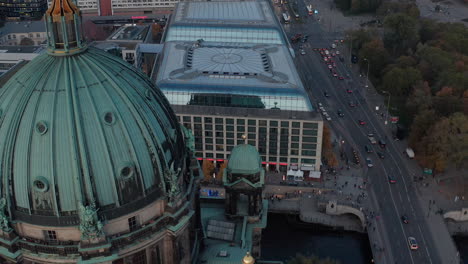 Descending-footage-of-large-green-dome-of-Berlin-Cathedral.-Close-up-view-of-roof-and-decoration.-Rush-hour-in-street-under.-Berlin,-Germany.