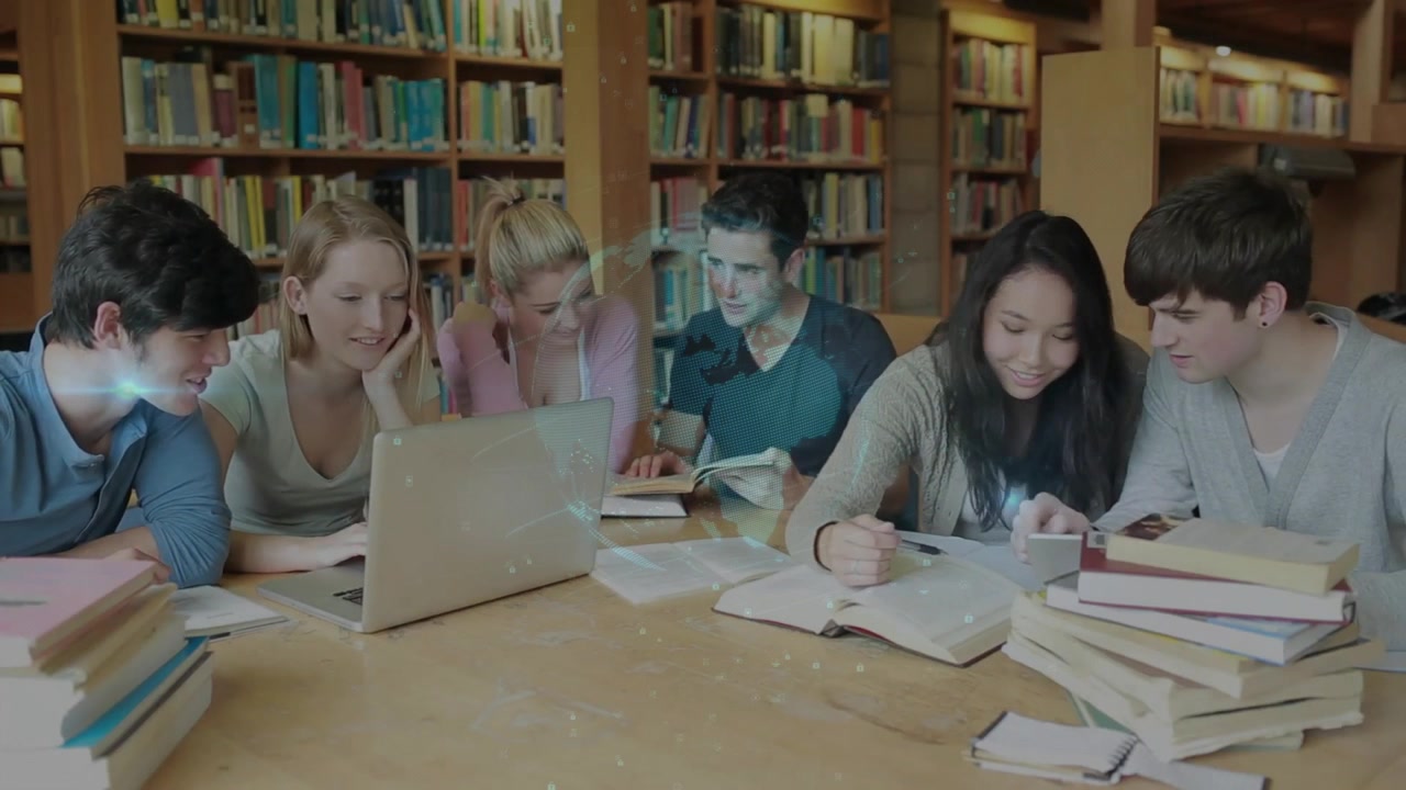 Blonde student leaning over laptop in library, enabling glowing study diagram emerging above table