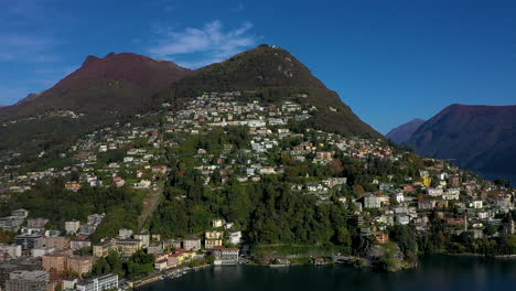 aerial view of a town on a lake surrounded by mountains